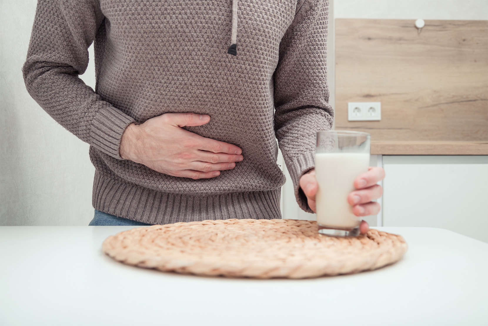 muž-sa-drží-za-brucho-so-sklenicou-mlieka-v-ruke